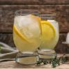Zwei Gläser Zitronenschorle mit Eiswürfeln und Zitronenscheiben